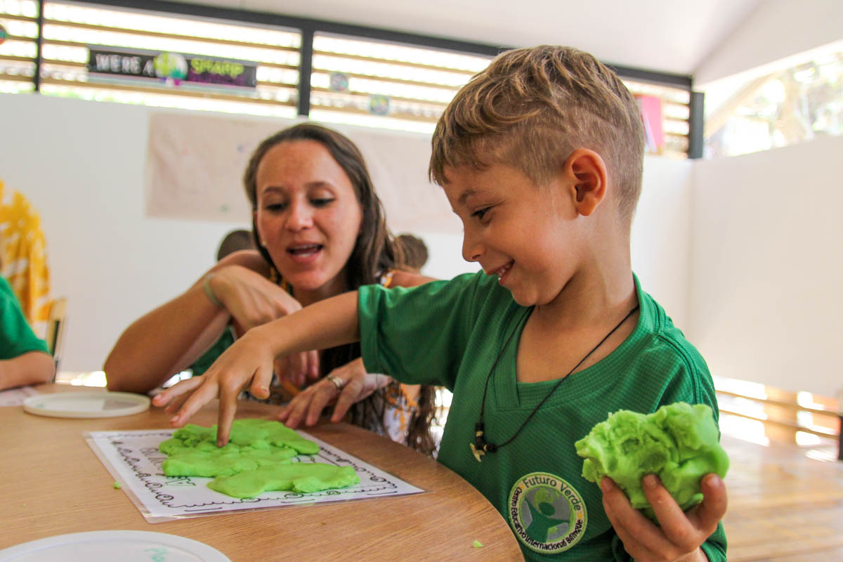 Preschool student and teacher playing with dough